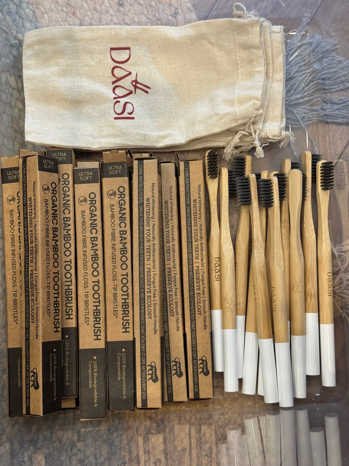 Dantya bamboo toothbrushes with organic bamboo toothbrush retail packaging and the DAASI branded canvas pouch